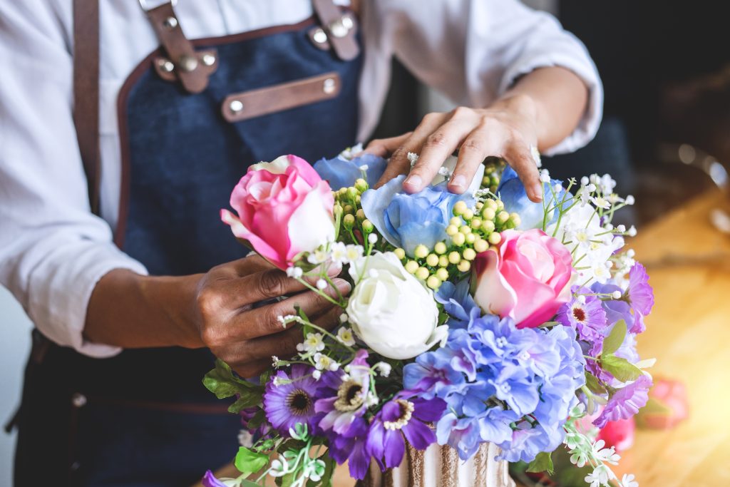 Arranging artificial flowers vest decoration at home, Young woman florist work making organizing diy artificial flower, craft and hand made concept.