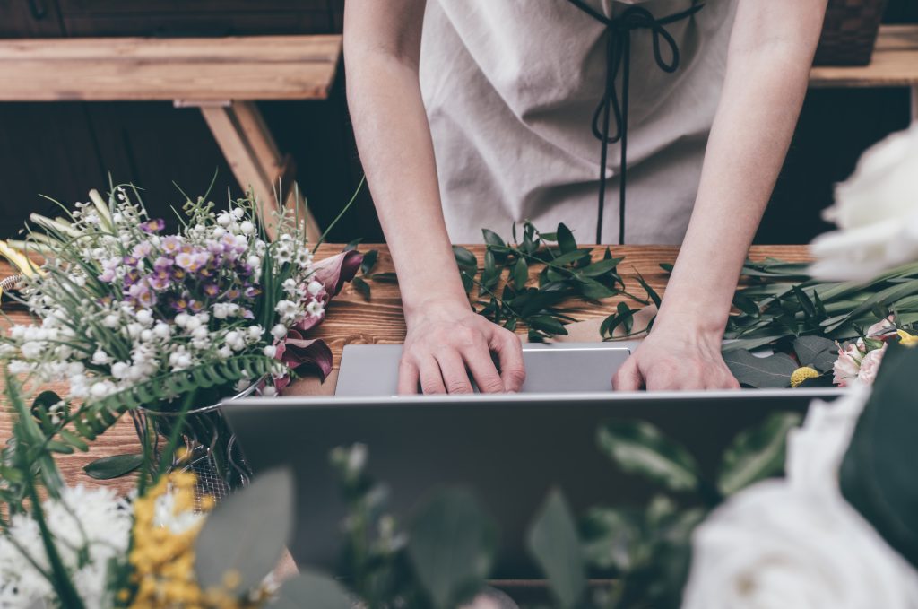 Florist working with laptop in a flower shop