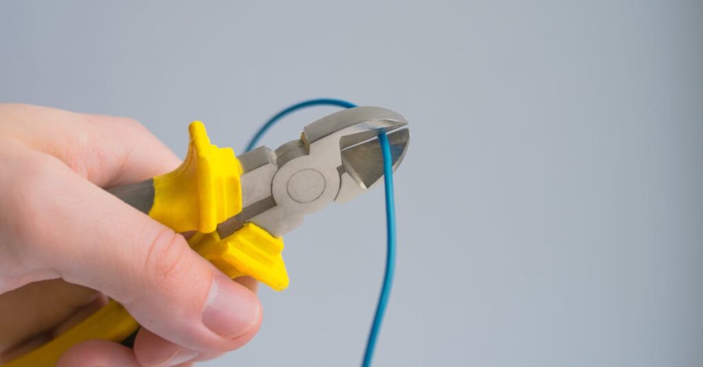 detailed image of a hand using pliers to cut a blue wire on a gray background