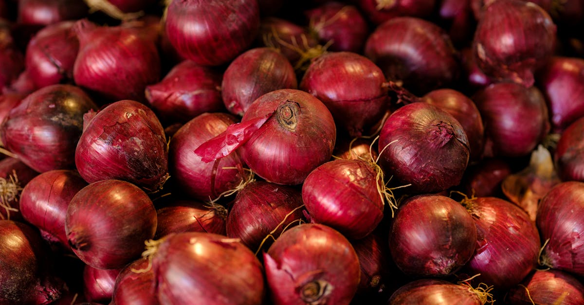 a close up of a large selection of fresh red onions showcasing their vibrant color and