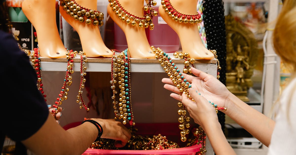 a display of colorful beaded anklets in a jewelry store setting featuring hands touching the items