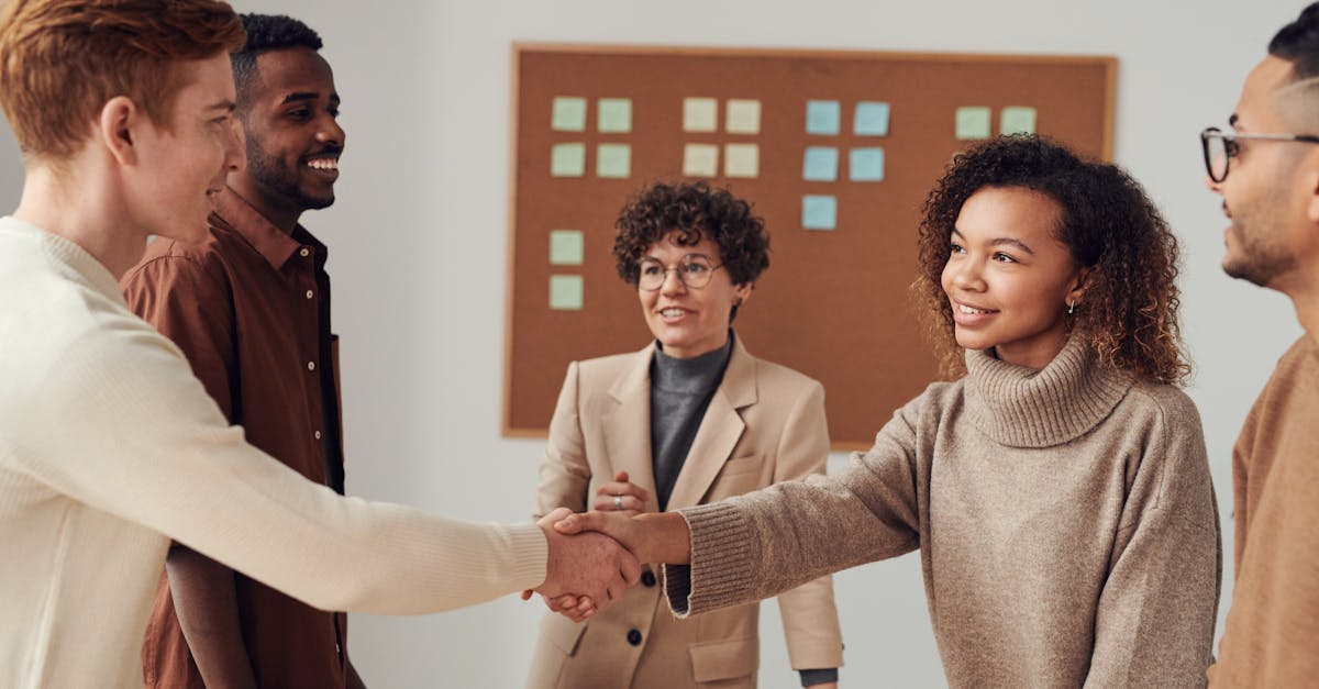 a diverse group of colleagues shaking hands during a productive office meeting