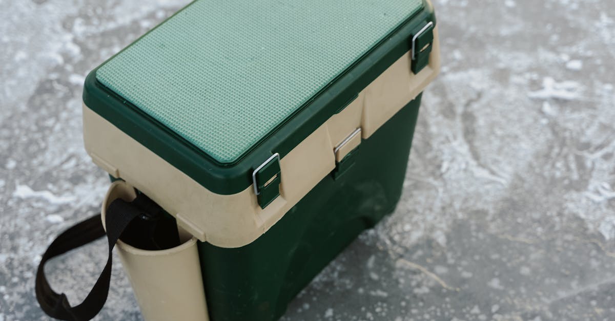 a green and beige cooler sits on a frozen ice surface ideal for outdoor adventures 1