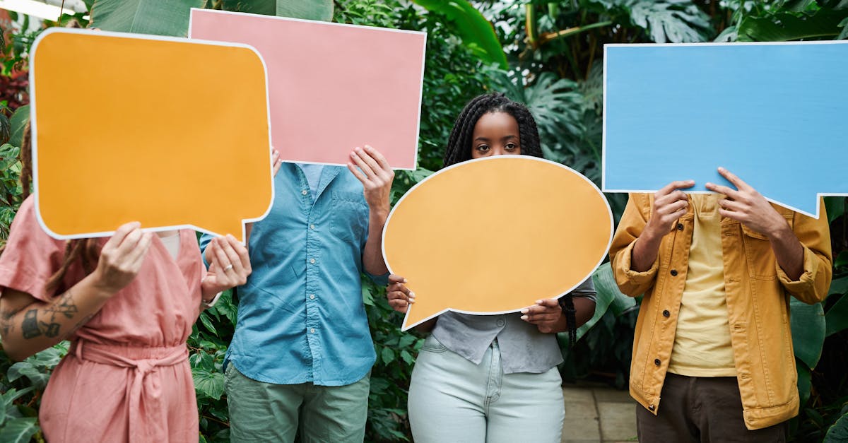 a group of adults holding colorful speech bubble signs in a lush greenhouse setting 9