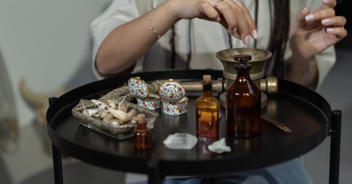 a hand engaging in a spiritual ritual with herbs and bottles on a mystical table