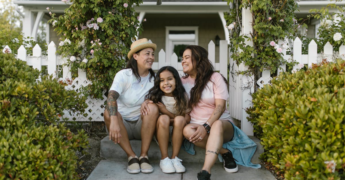 a joyful family of three sitting together outside their home showing love and happiness
