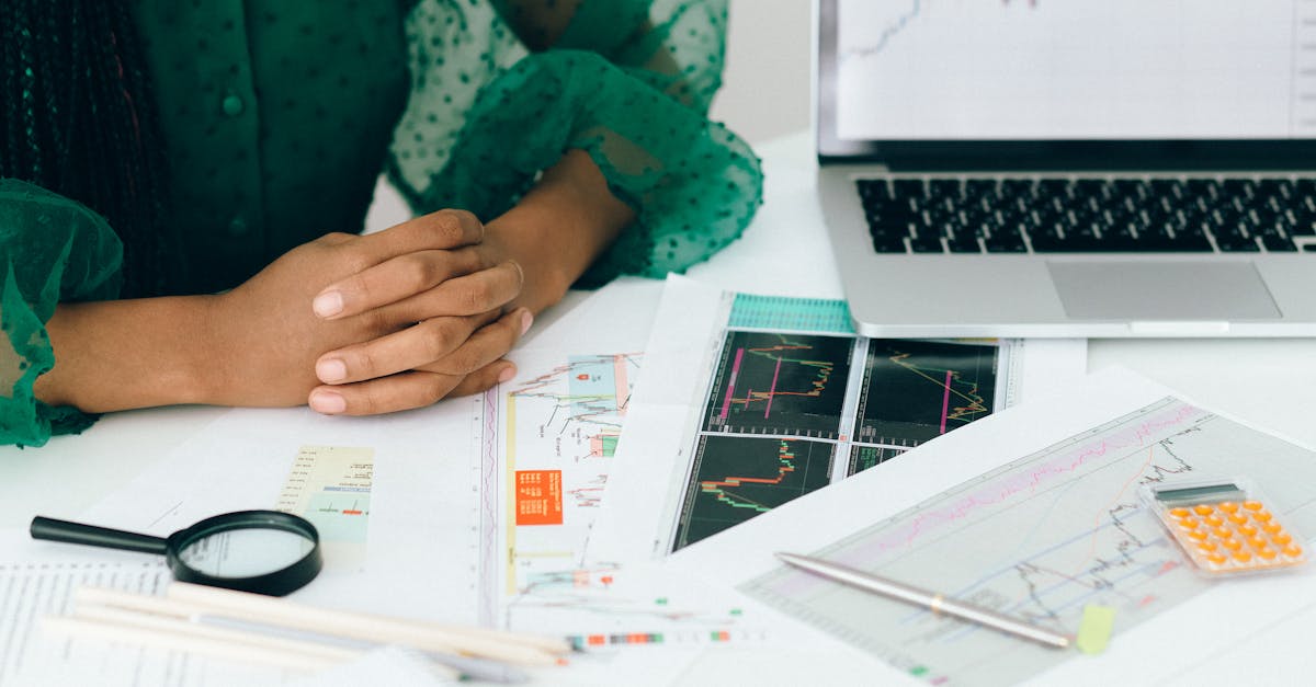 a person analyzes financial charts and graphs at a desk indicating business trading activity 3