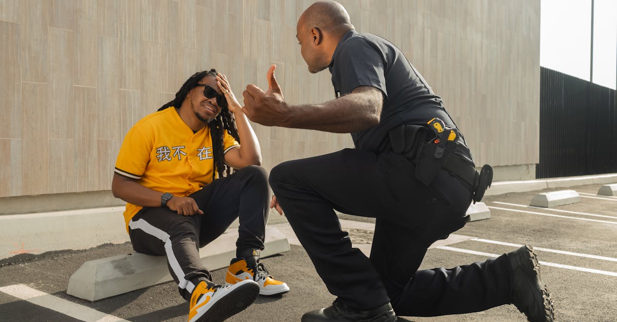 a police officer interacts with a man in a yellow shirt in a parking lot