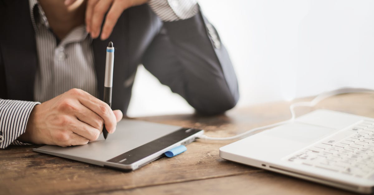 a professional working with a graphic tablet and laptop in a modern office environment