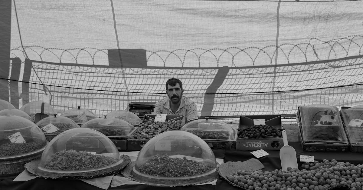 a traditional market vendor displaying a variety of dried fruits and nuts under a canopy