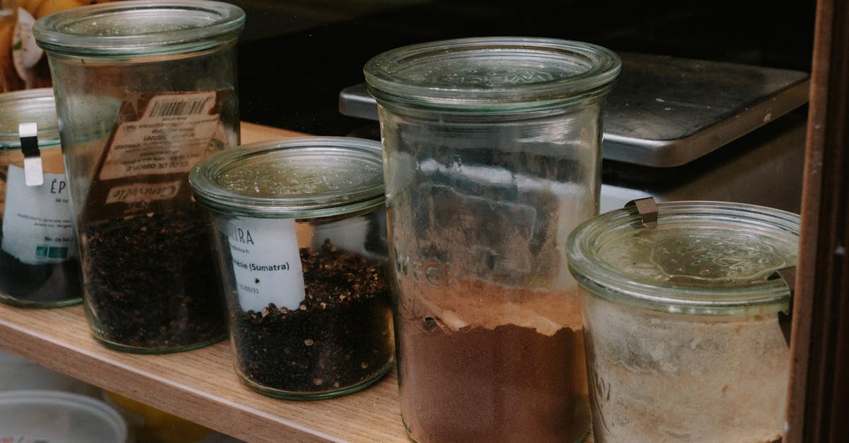 a variety of spices stored in glass jars lined on a shelf perfect for kitchen organization
