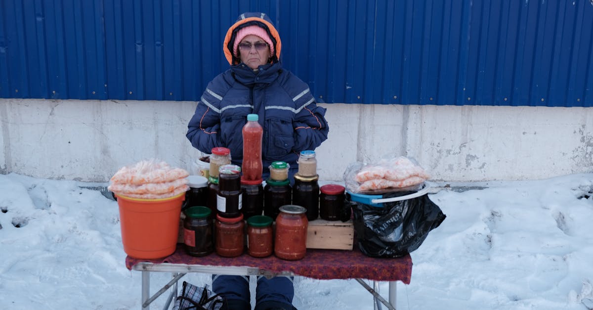 a vendor selling homemade sauces and preserves at an outdoor winter market