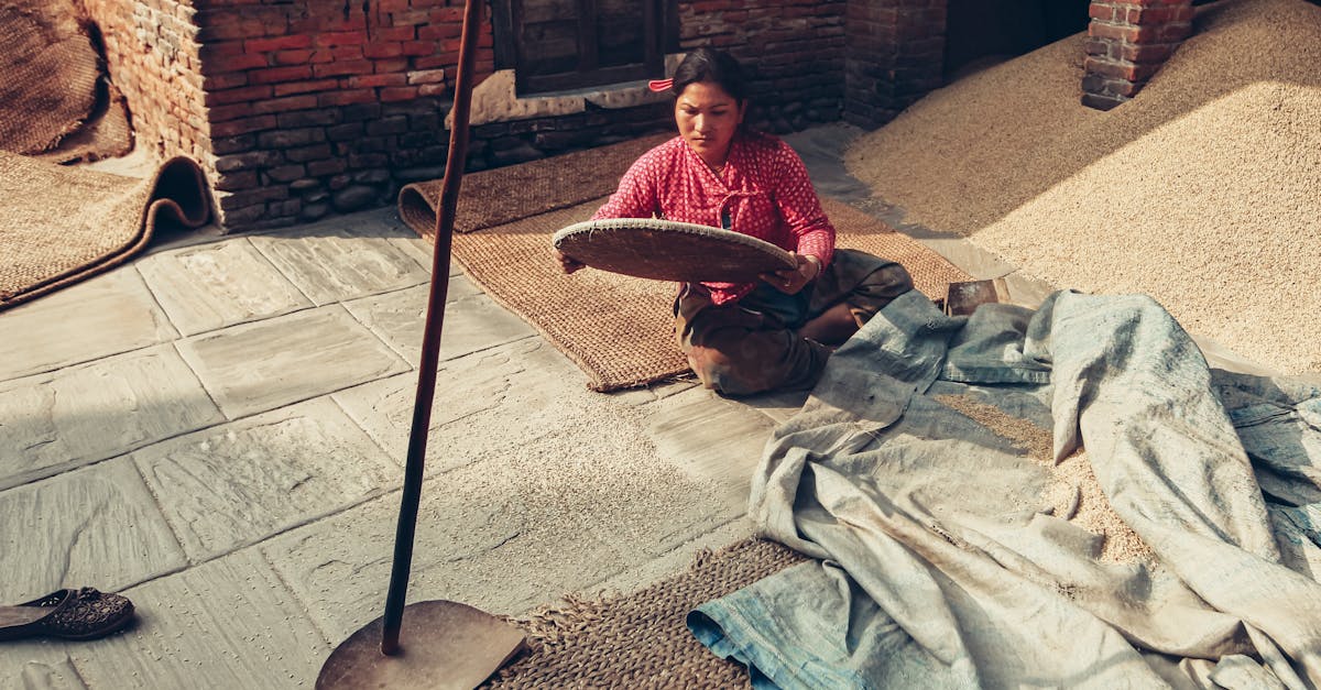 a woman in a traditional setting sieving grain outdoors reflecting rustic and rural lifestyle 2