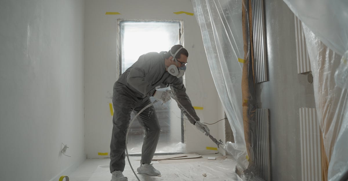 a worker in protective gear painting walls during an indoor renovation project 1