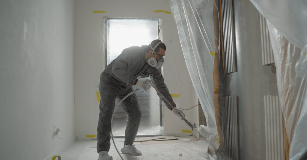 a worker in protective gear painting walls during an indoor renovation project