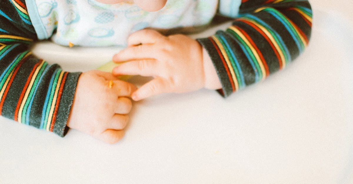 adorable baby playing with food on a high chair indoors highlighting innocence and curiosity 3