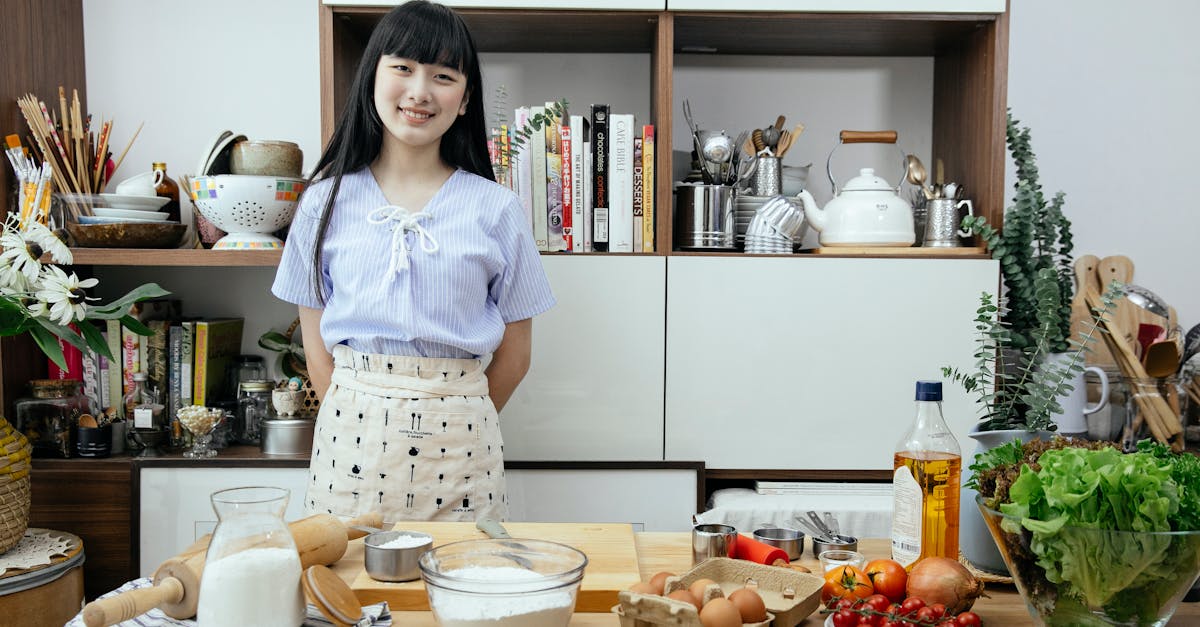 asian woman smiling in a modern kitchen with fresh ingredients prepped for cooking