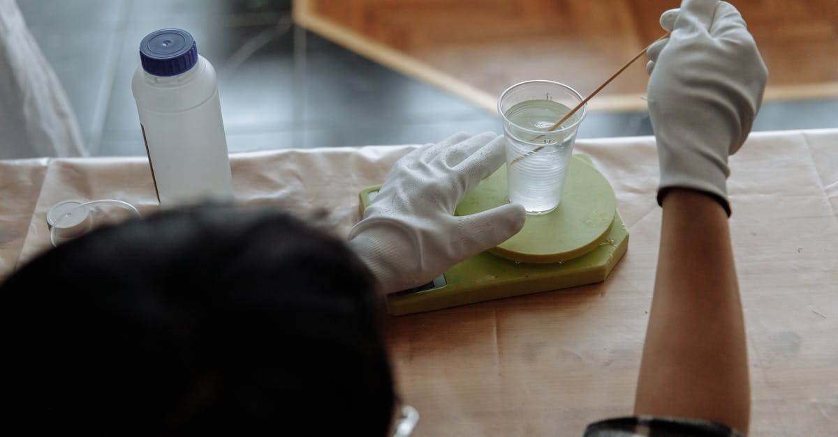 close up of a man mixing resin with gloves in an indoor workshop setting 1