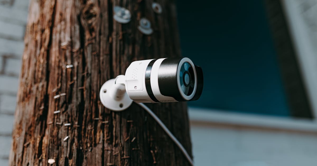 close up of a modern security camera mounted on a wooden post outdoors 1