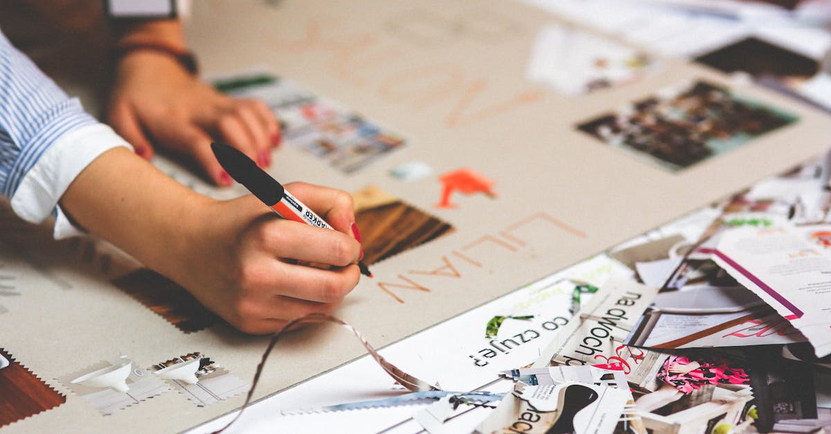 close up of a person writing and crafting at a cluttered desk workspace 1