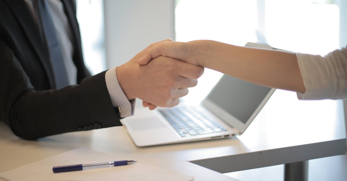 close up of a professional handshake over a laptop during a business meeting in an office 3