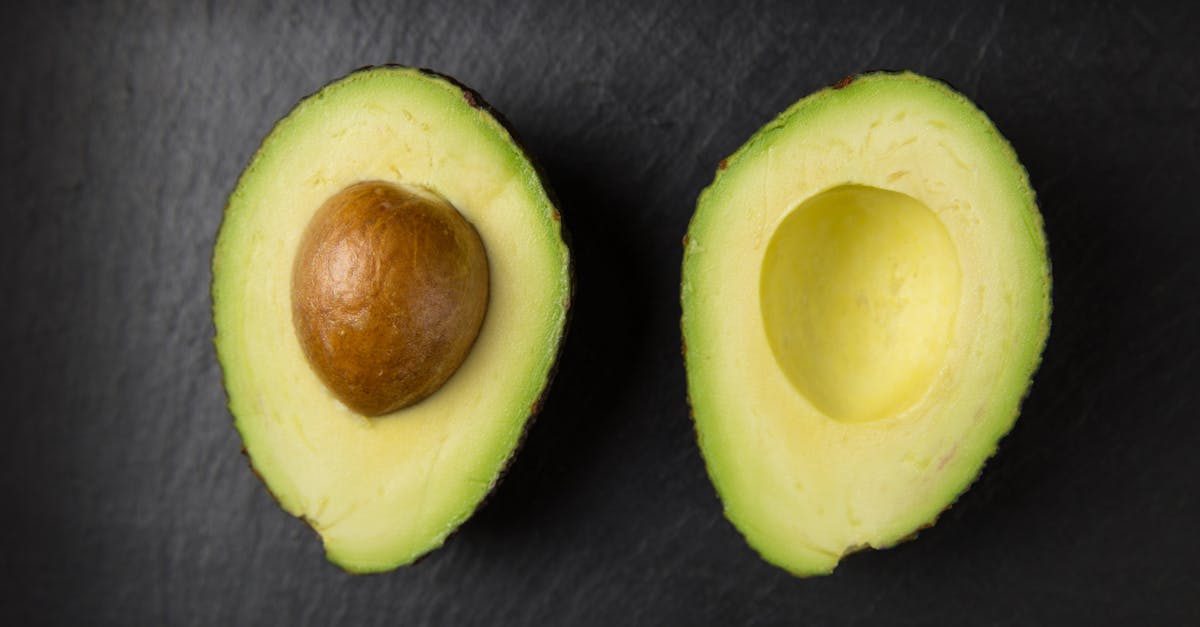 close up of fresh sliced avocado halves on a dark slate surface showcasing healthy eating