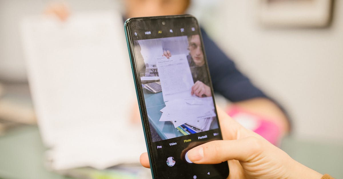 close up of student using smartphone to photograph examination papers in a classroom setting
