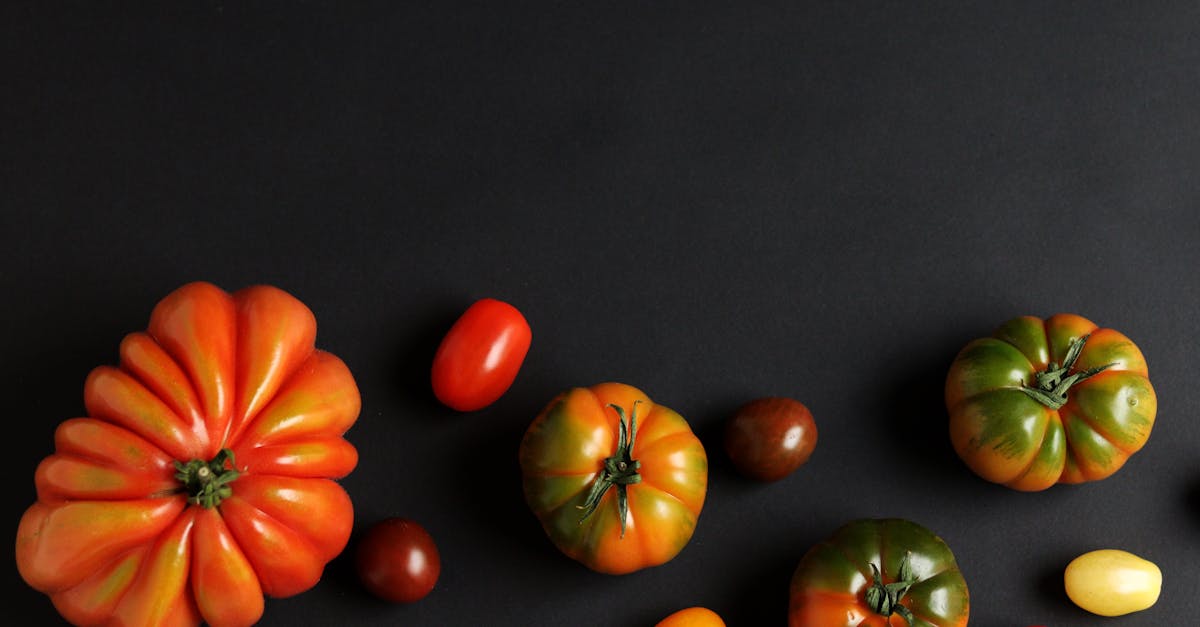 colorful heirloom tomatoes arranged artistically on a black background ideal for food photography