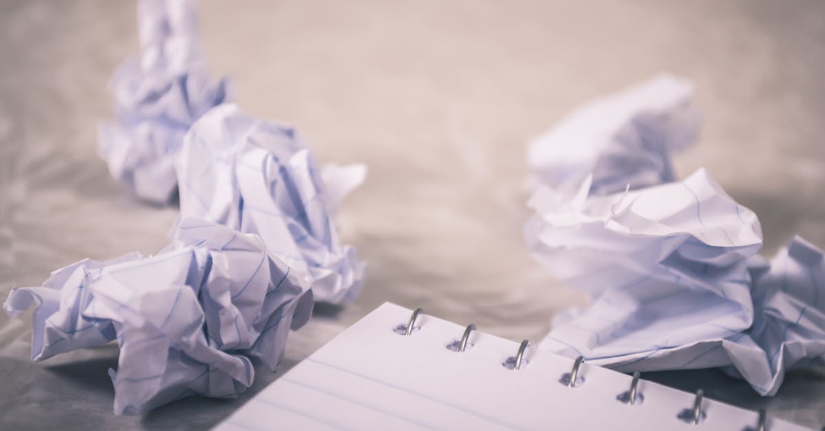 crumpled papers scattered around a notepad symbolizing creative process and ideas