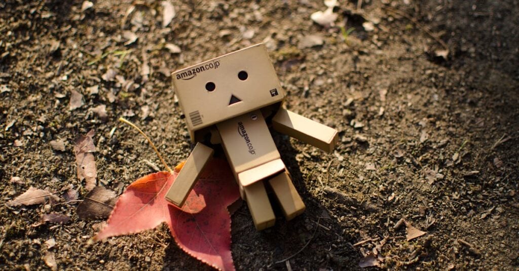 cute cardboard robot toy on a dirt surface with autumn leaves capturing a whimsical moment 1