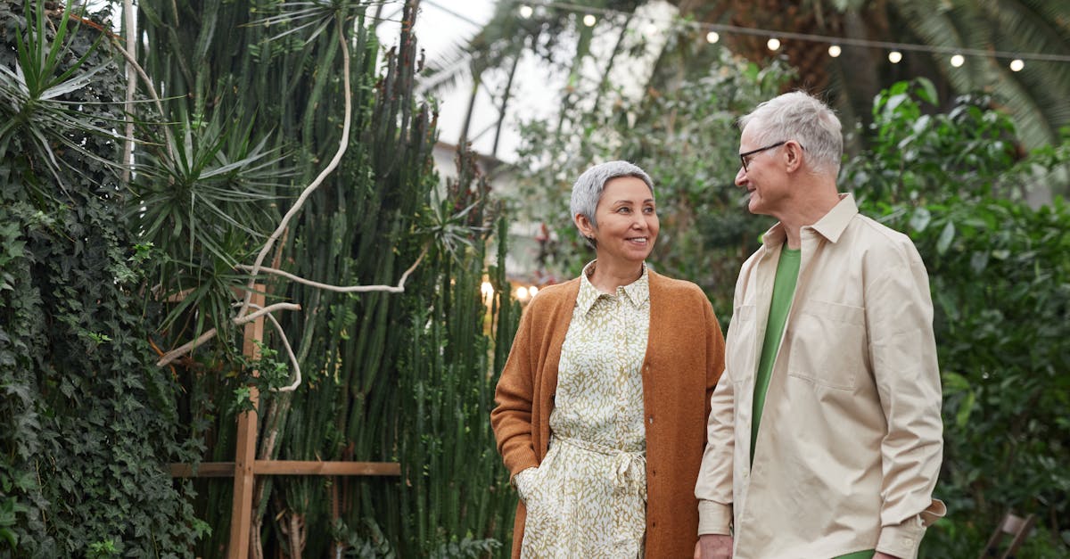 elderly couple enjoying a walk in a vibrant greenhouse surrounded by greenery