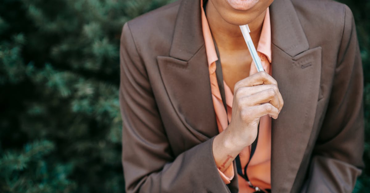 high angle of crop female entrepreneur in formal wear touching chin with pen while thinking on solut 2