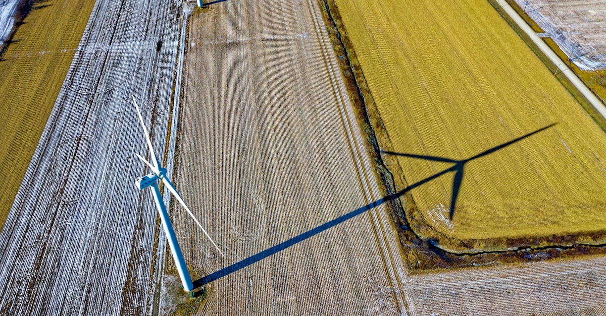 high angle shot of wind turbines casting shadows on farmland in dodge center mn