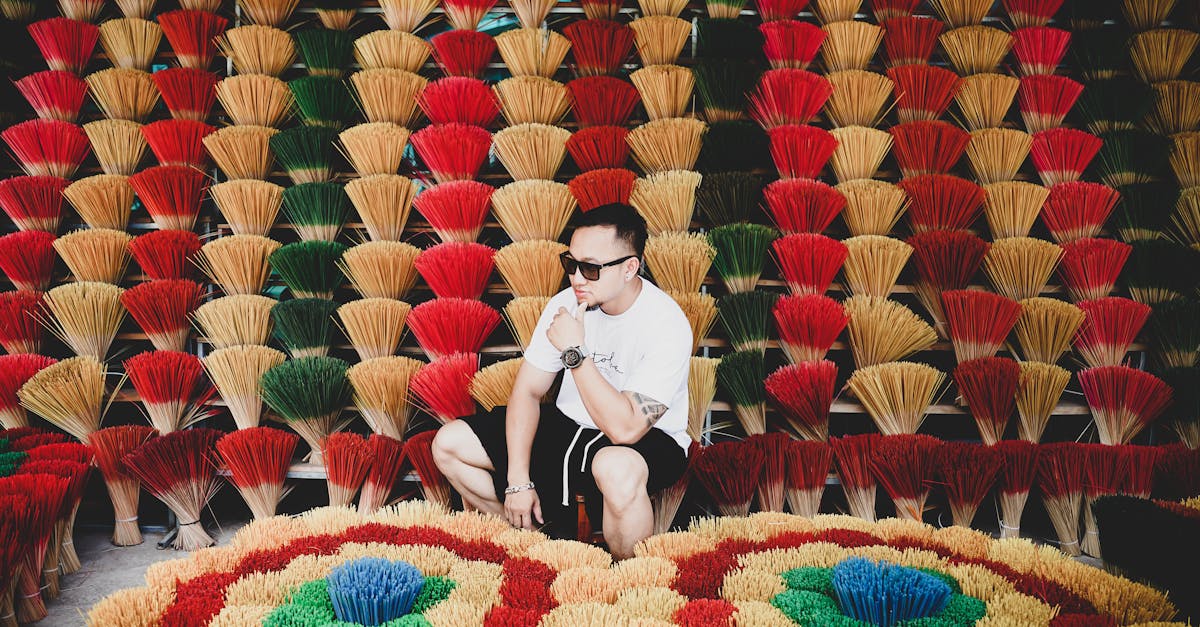 man among colorful handmade incense sticks display in traditional market setting