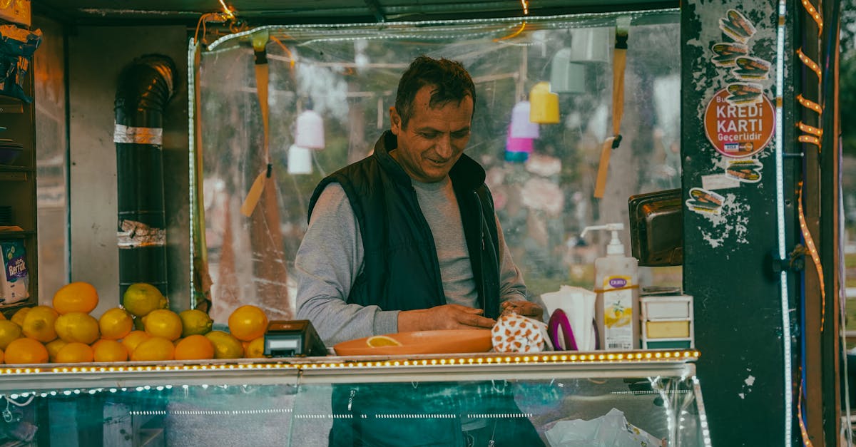 man at fruit stall in isparta turkiye preparing produce for sale surrounded by vibrant colors