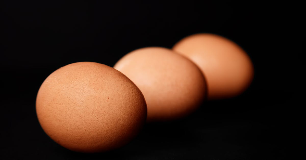 minimalist still life of three brown eggs on a dark background highlighting simplicity and natural