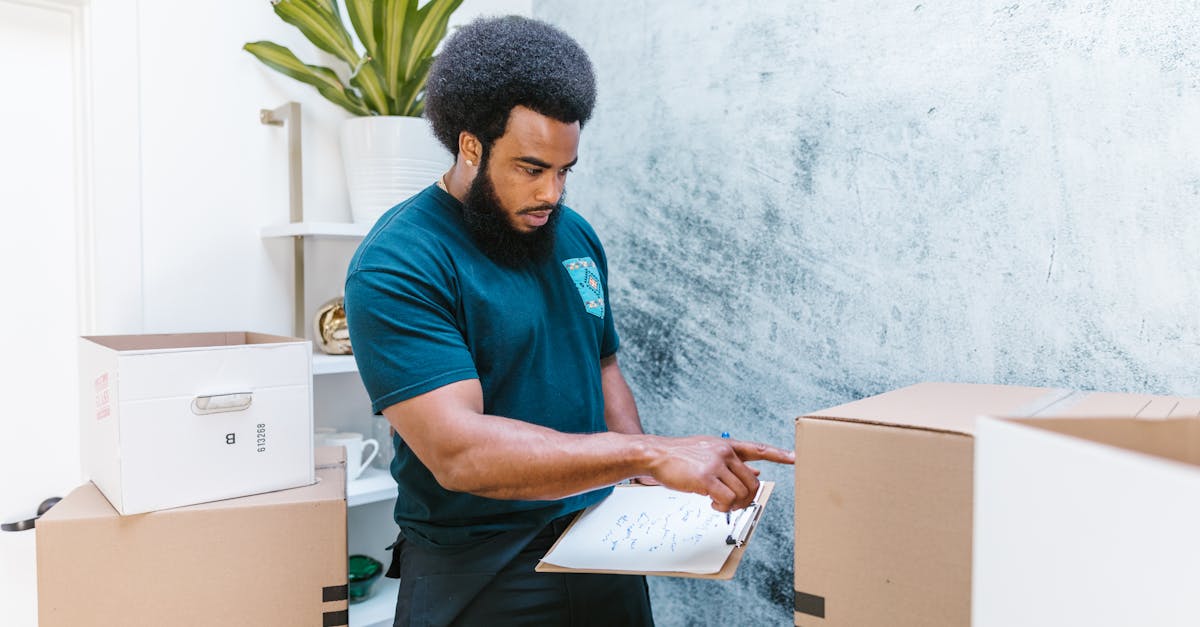 mover checking inventory list while organizing cardboard boxes in a new apartment