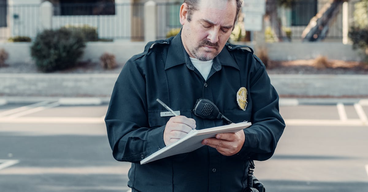 police officer in uniform writing a ticket on a clipboard outdoors