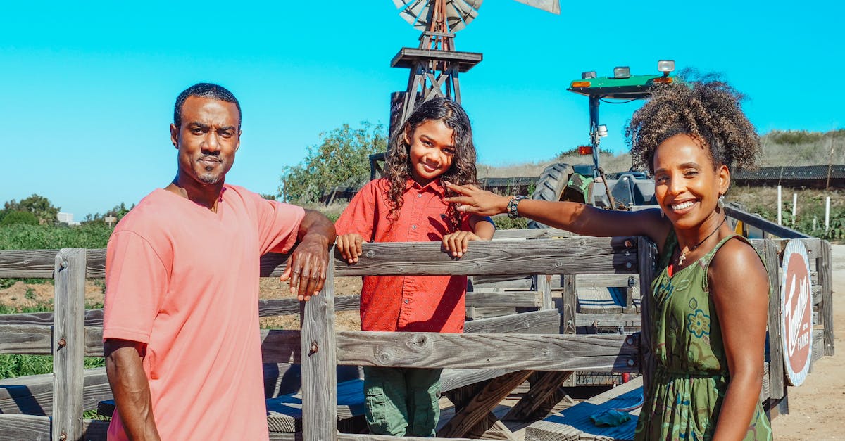 smiling family of three at the farm with windmill background
