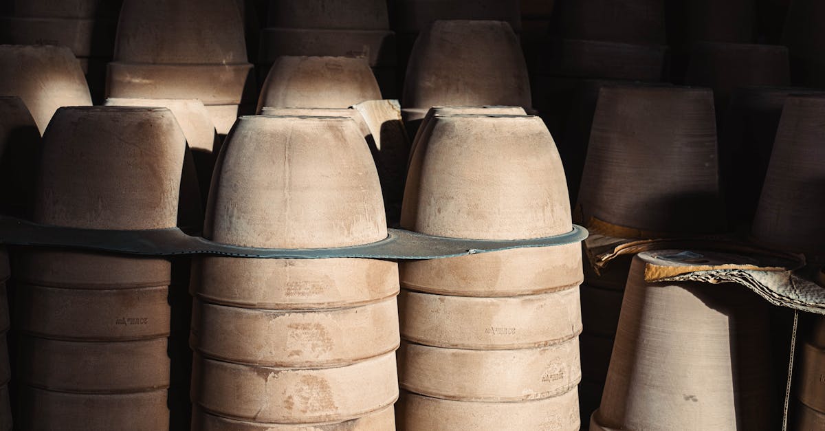stacks of clay pottery in a warehouse setting with soft light
