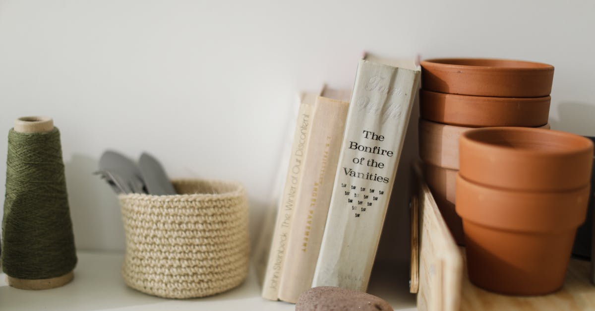 still life of crafting tools and books on a shelf with terracotta pots and thread 2