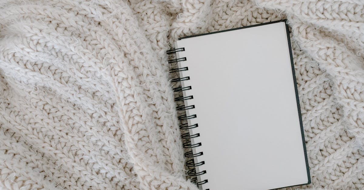 top view of an empty spiral notebook resting on a soft knitted blanket perfect for cozy themes
