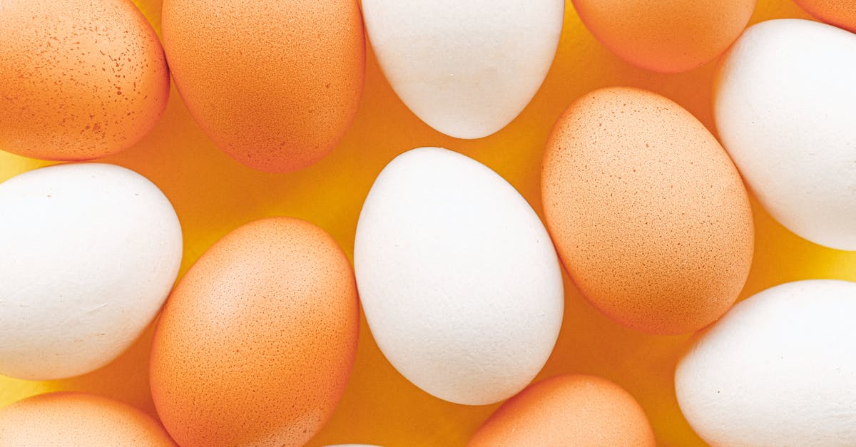 top view of brown and white eggs arranged on a vibrant yellow surface offering a minimalistic food