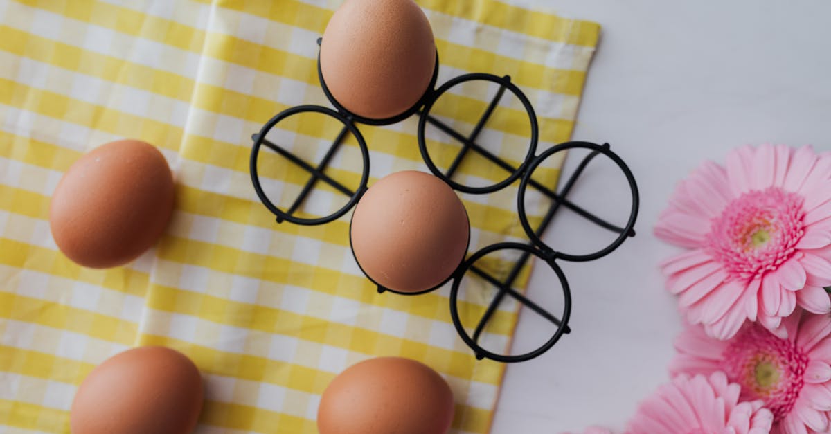 top view of brown eggs on a yellow checkered cloth with pink flowers spring theme