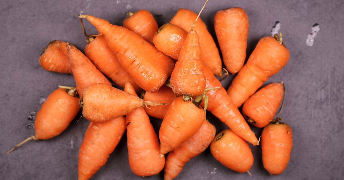 top view of fresh organic carrots on a dark surface highlighting their vibrant orange color