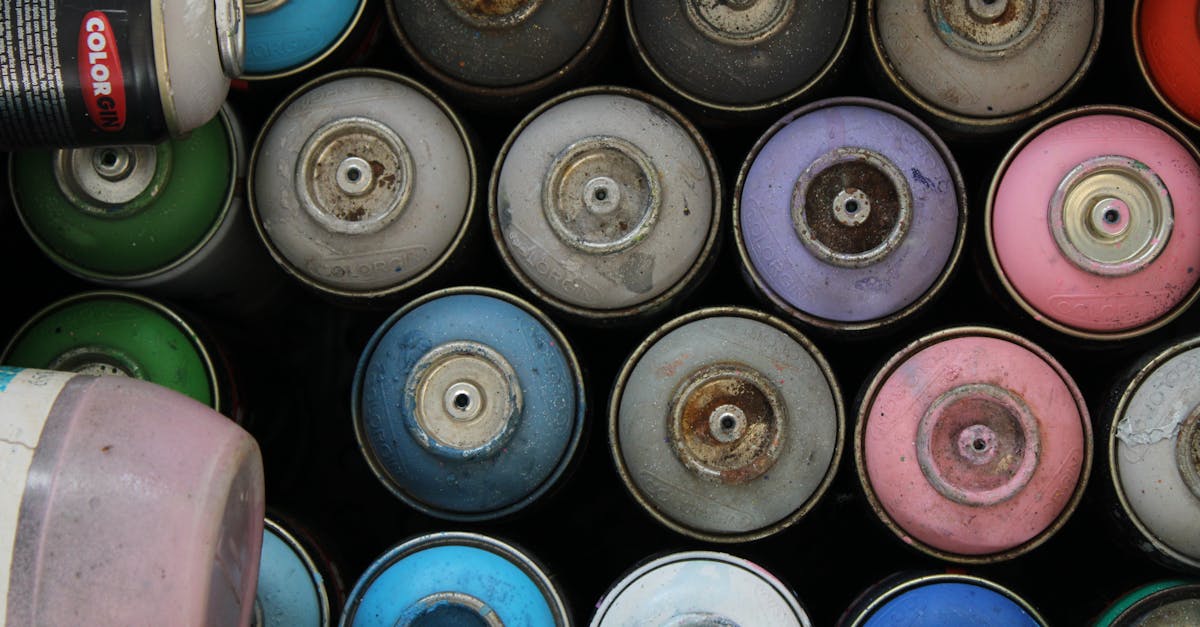 top view of various colorful and rusty spray paint cans in storage