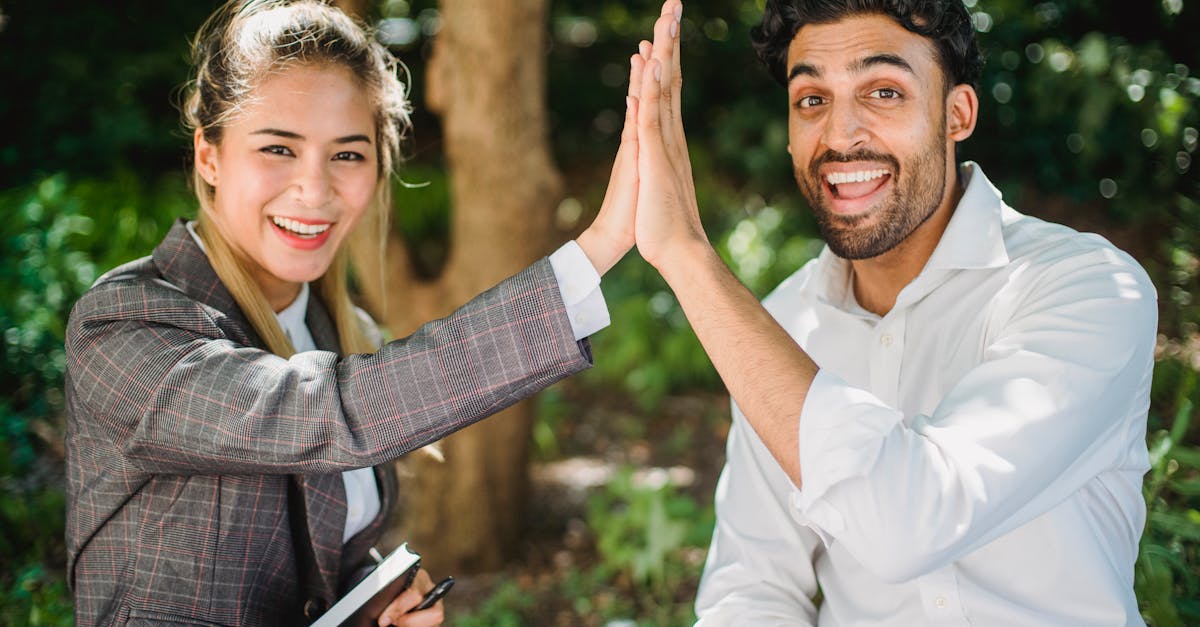 two colleagues high five outdoors symbolizing teamwork and success