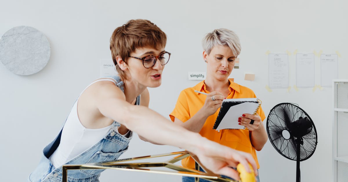 two women collaborating on a design project one sketching and the other planning 1