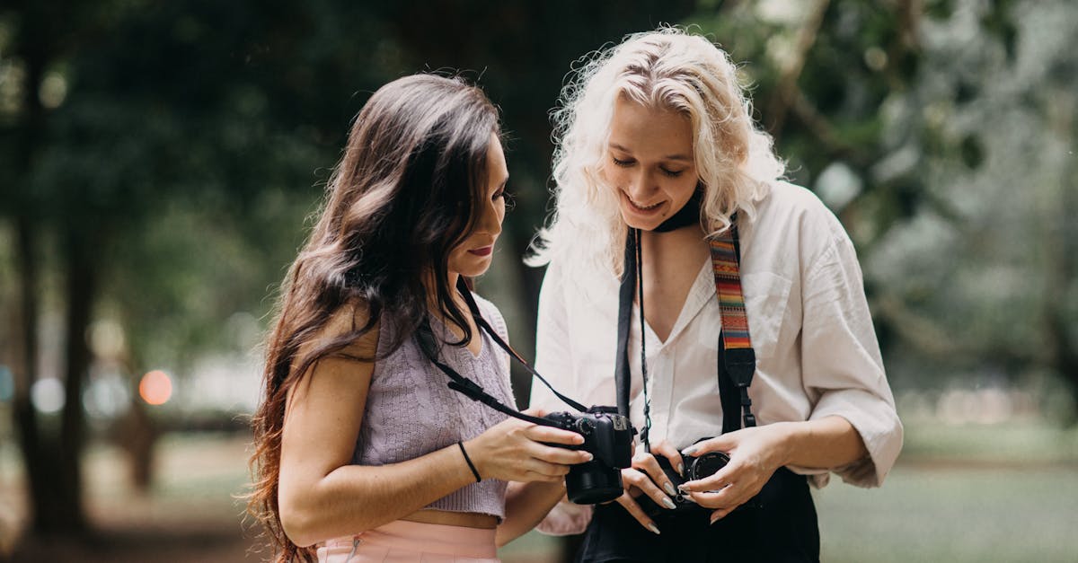 two women enjoying photography together sharing tips with cameras in a lush park setting 1