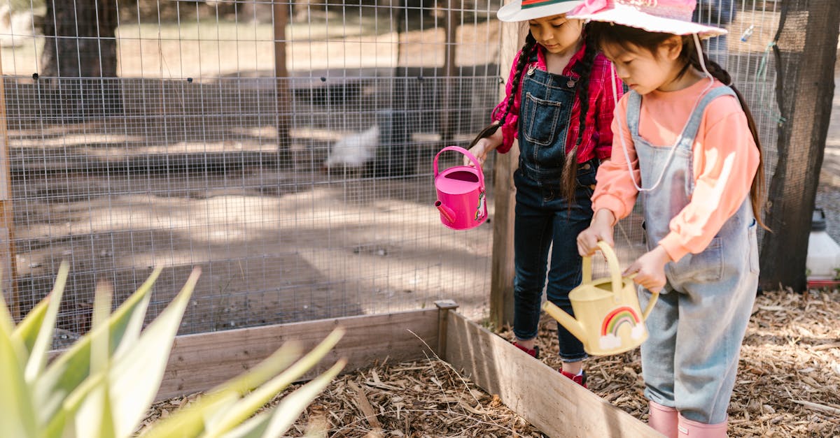 two young girls gardening outdoors with watering cans and sun hats fostering nature appreciation